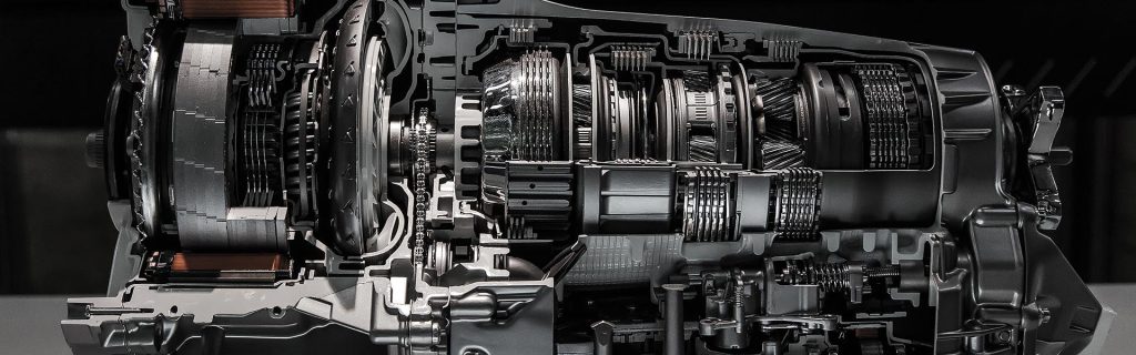 A cutaway view of an automotive transmission, showing the intricate internal gears, clutches, and mechanical components.